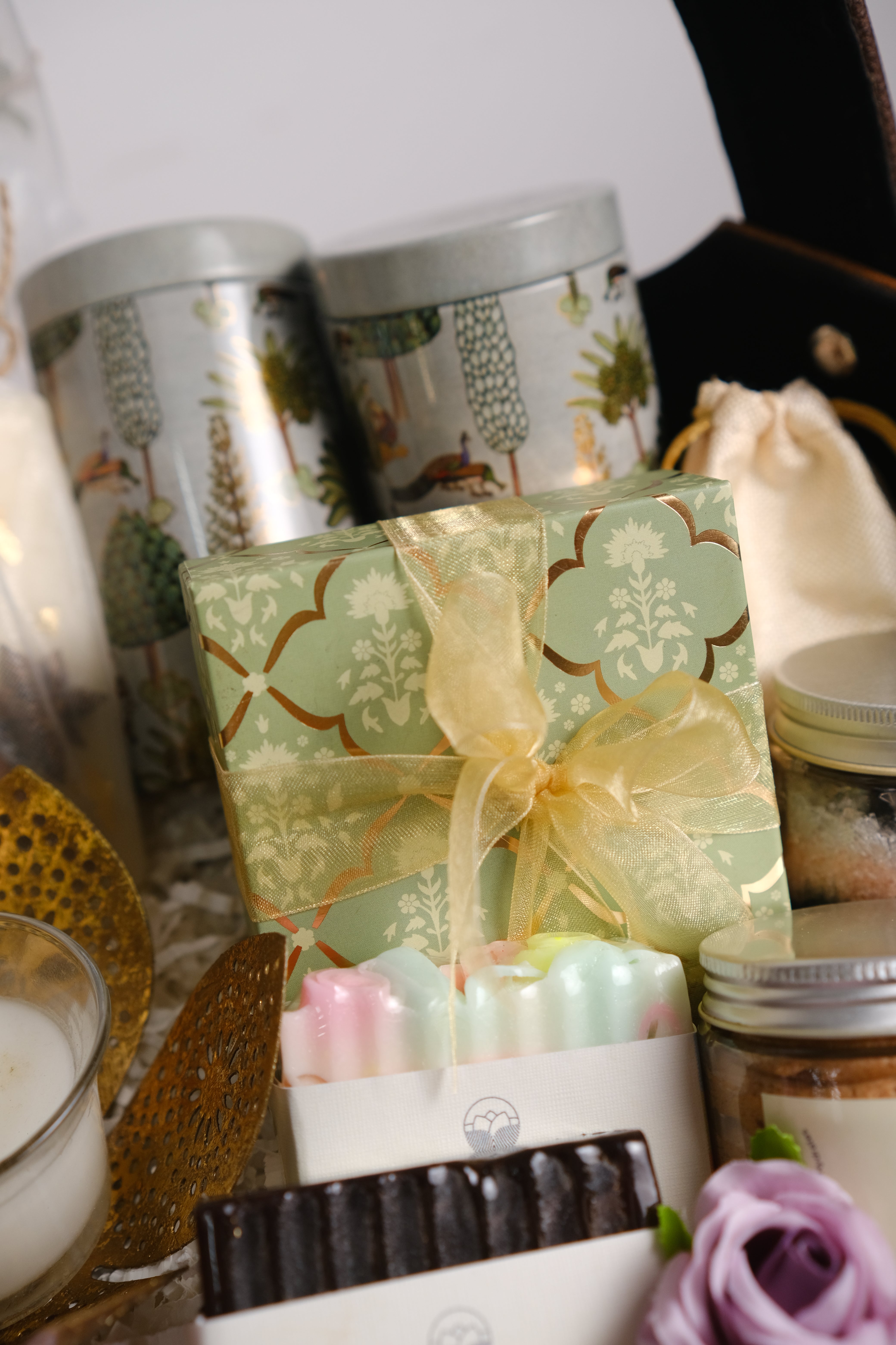 Gift box with decorative bow on a surface with floral and patterned elements.